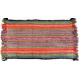 A hand knotted coarse woollen rug with bands of red, blue and green decoration,