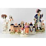 A group of five late 19th/early 20th century Staffordshire figures to include poacher with rabbits,