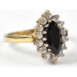 A 9ct yellow gold ring set with central marquise cut sapphire surrounded by white stones, size N1/2,
