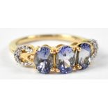 A 10ct yellow gold ring set with three tanzanite and cubic zirconium to the shoulders, size N,
