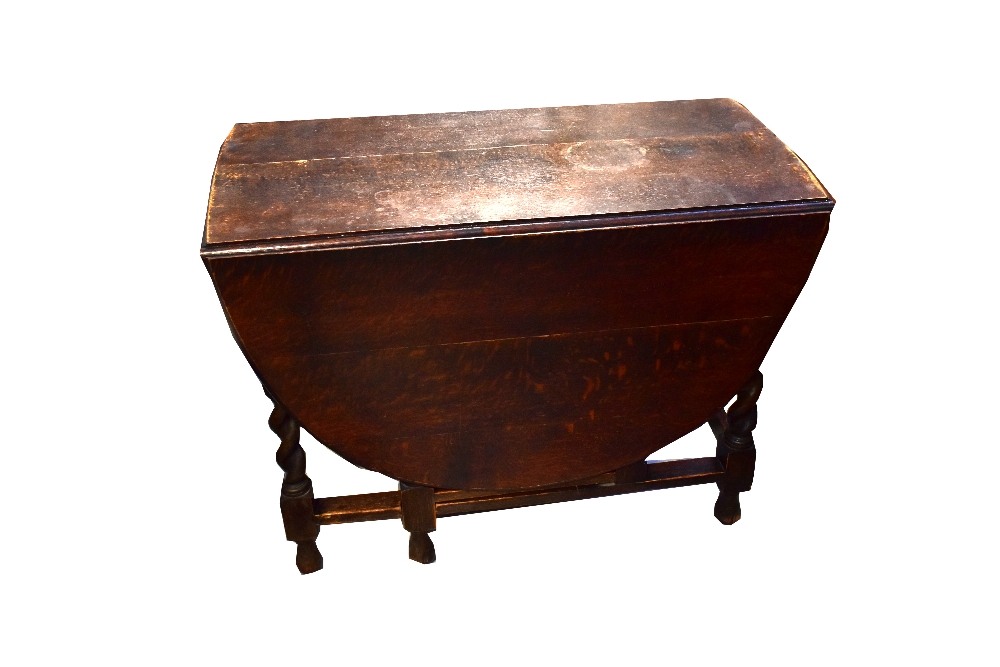 A 19th century drop-leaf gateleg table to wrythen supports, cross-stretcher and ball feet,