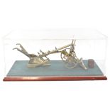 A well detailed brass model of a plough, presented in perspex case, length of case 37.5cm.