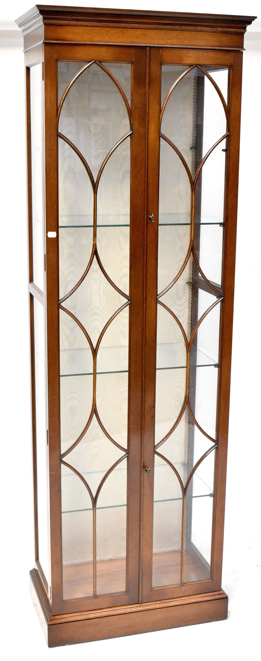 An Edwardian floor standing display cabinet, stepped frieze above twin astragal glazed doors,