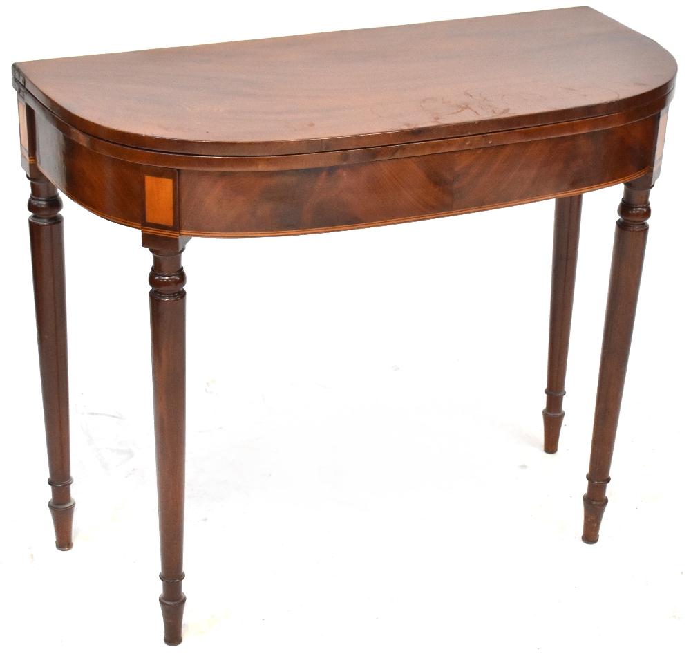 A 19th century mahogany fold-over tea table to tapering supports and peg feet,