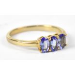 A 9ct yellow gold ring set with three tanzanites, size L, 1.8g.