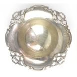 A George V hallmarked silver bonbon dish with shaped border comprising pierced ribbon and scroll