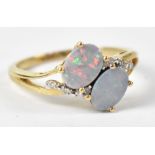 A 10ct yellow gold ring set with two opals set on ironstones and tiny chip diamonds to the