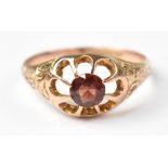 A 19th century 9ct rose gold ring with claw set red stone in an open mount, size S, approx 2.8g.