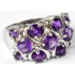 A 9ct white gold ring set with eleven amethysts in three rows in open claw settings, size P,