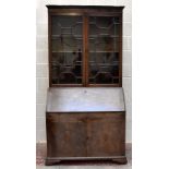 A George III mahogany bureau bookcase, with dentil cornice above two astragal glazed doors enclosing