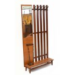 A mid century teak wall mounted hall stand, with five slats with black metal pegs, flanked to the