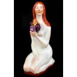 MARTIN WIEGAND; a ceramic figure representing a kneeling nude maiden clutching flowers, with