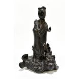 A 19th century Chinese porcelain figure representing Guan Ying standing on a mythical creature,