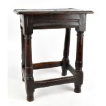 An 18th century oak joint stool of typical construction raised on tapering columns terminating on