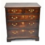 A George III oak chest, the rectangular top with a moulded edge above two short and three