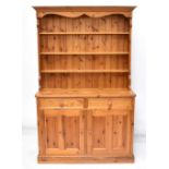 A modern pine dresser with plate rack back, the boarded back with three fixed shelves above the base
