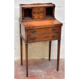 A reproduction mahogany veneered writing table with three drawers flanked by two pigeonholes,