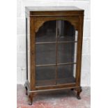 An early 20th century mahogany and oak effect cabinet, with single glazed door raised on cabriole