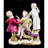 MEISSEN; a porcelain group of a maiden seated upon a chair with two attendants beside, on rococo