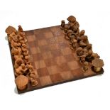 ETHNOGRAPHIA; a Nigerian West African carved wood chess set with a chess board, the board 30.5 x