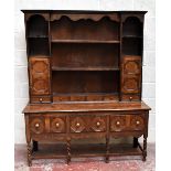 An 18th century oak dresser in a Jacobean style, with plate rack back and three fixed shelves