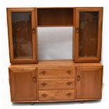 ERCOL; an elm display cabinet, with two glazed doors above an arrangement of three drawers and two