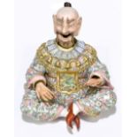 A late 19th century German porcelain nodding figure modelled as a seated bearded Chinese elder