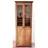 A 19th century mahogany narrow bookcase, with pair of glazed doors above pair of panel doors,