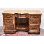 A Victorian knee hole dressing table with serpentine shaped central drawer flanked by two banks of