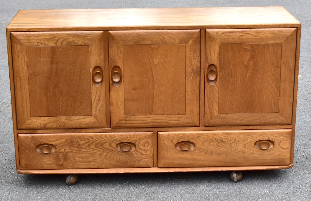 ERCOL; a light elm sideboard, the three panel doors above two base drawers, width 129cm, depth 43cm,