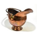 A late Victorian copper and brass helmet shaped coal scuttle, raised on socle base, height including