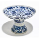 A Chinese blue and white stem cup, the upper section decorated throughout with flowers, the flared