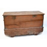 A large teak chest of rectangular form, with applied carved metal detail to the corners and front,