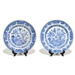 A pair of 18th century Chinese Export blue and white chargers painted with still life scenes and