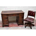 A reproduction mahogany kneehole desk with maroon leather inset top above an arrangement of eight