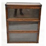An early 20th century oak metal bound three tier Globe Wernicke style stacking bookcase, with up and