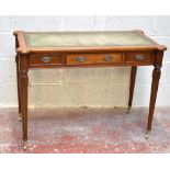 A reproduction walnut writing table with green leather inset top, with three central drawers