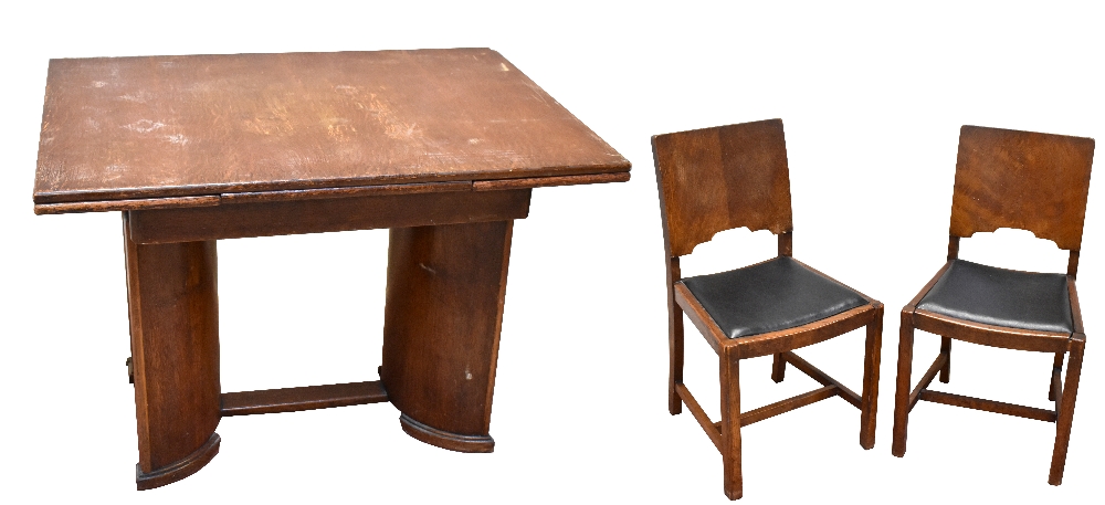 A late Art Deco oak extending dining table and four chairs, the rectangular table with two pull