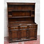 A reproduction oak dresser, with boarded back, two fixed shelves and two small drawers, above the