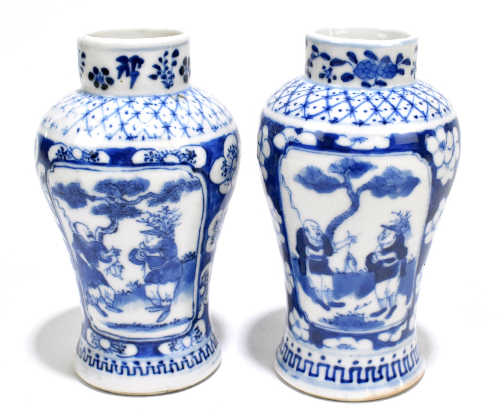 A pair of late 19th century Chinese Kangxi style blue and white vases, decorated with panels of
