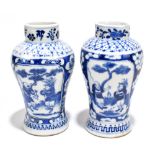 A pair of late 19th century Chinese Kangxi style blue and white vases, decorated with panels of