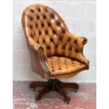 A reproduction brown leather Chesterfield type swivel desk chair.Additional InformationCracking to
