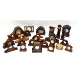 An assortment of oak, mahogany and other mantel clock cases, in various states of repair.