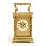 A 19th century French carriage clock, with cast decoration to the swing handle and corners, the