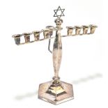 A silver plated menorah, raised on a central hexagonal column terminating on a plinth base, height