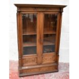An early 20th century Continental carved walnut bookcase, with applied gilded scrolling and floral