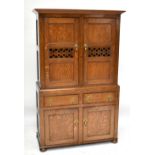 An 18th century Welsh oak cheese cupboard, the upper section with later cornice above a pair of