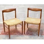 BRAMIN; a pair of Danish teak framed rush seated chairs raised on tapering column supports. .