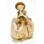 ROYAL DUX; a figural vase representing a boy playing a flute seated on a cube shaped base section,