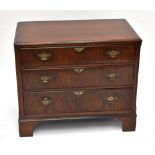 A reproduction mahogany chest of three drawers of small proportions with swan neck handles, raised